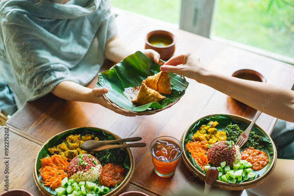 Woman enjoying food, meals in storage container, and food bowls on a table
